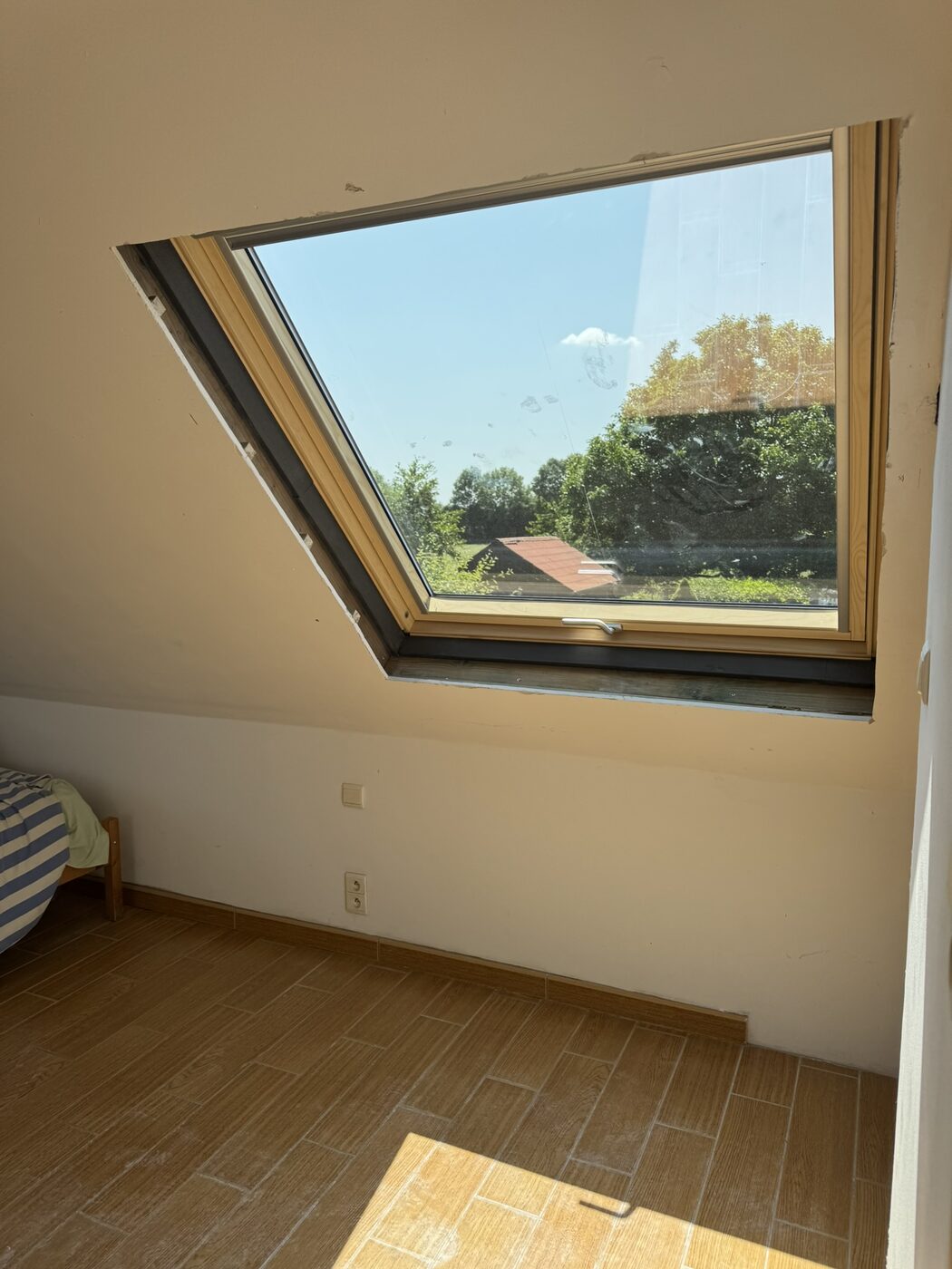 Combles éclairés par une fenêtre de toit Velux posée par Label Entreprise